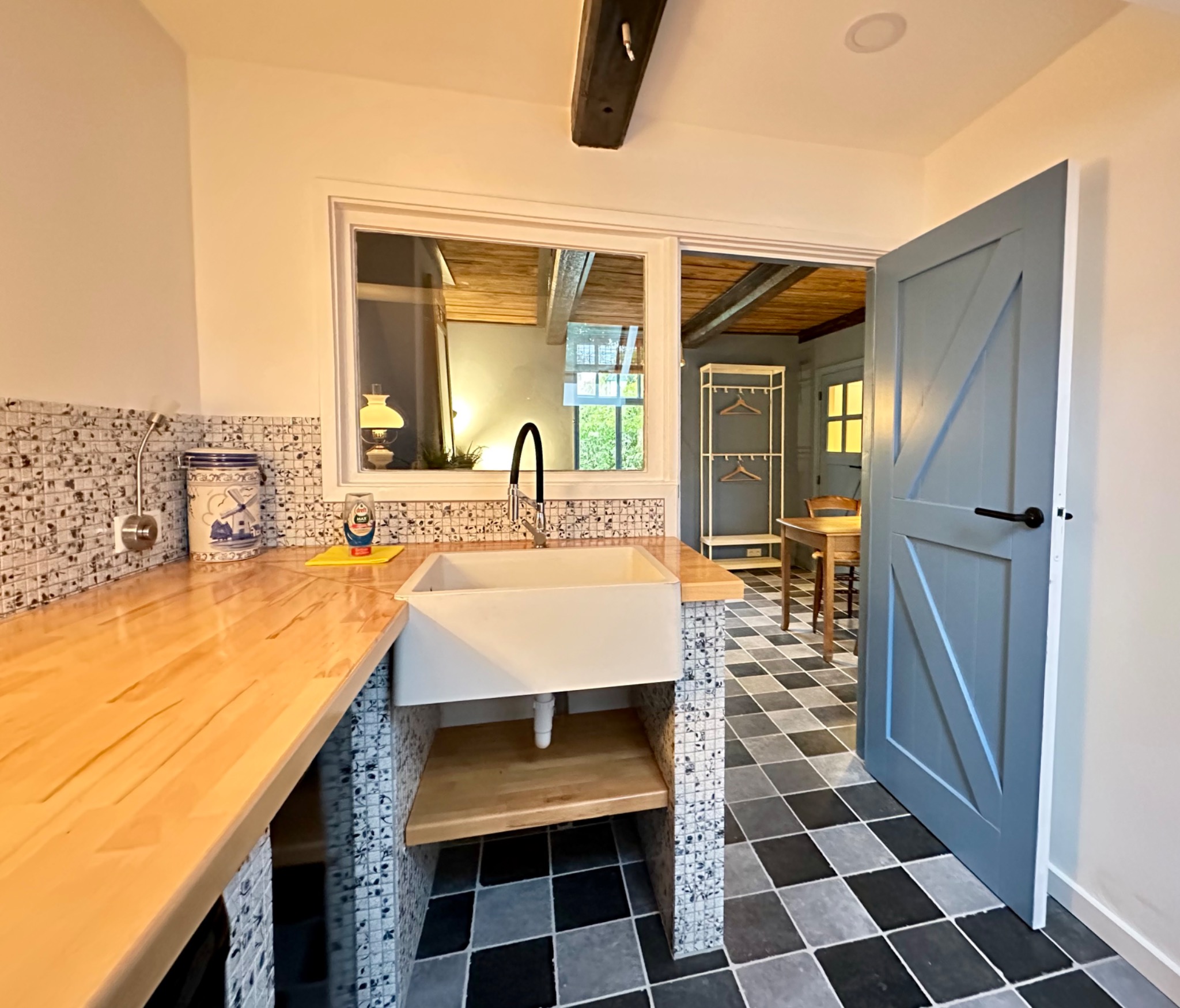 De ruime pantry met spoelbak en doorkijk naar de zitkamer.